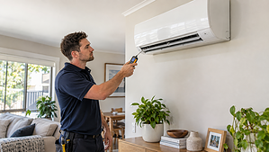 HVAC technician inspecting a split-system air conditioner blowing warm air in an Australian home.